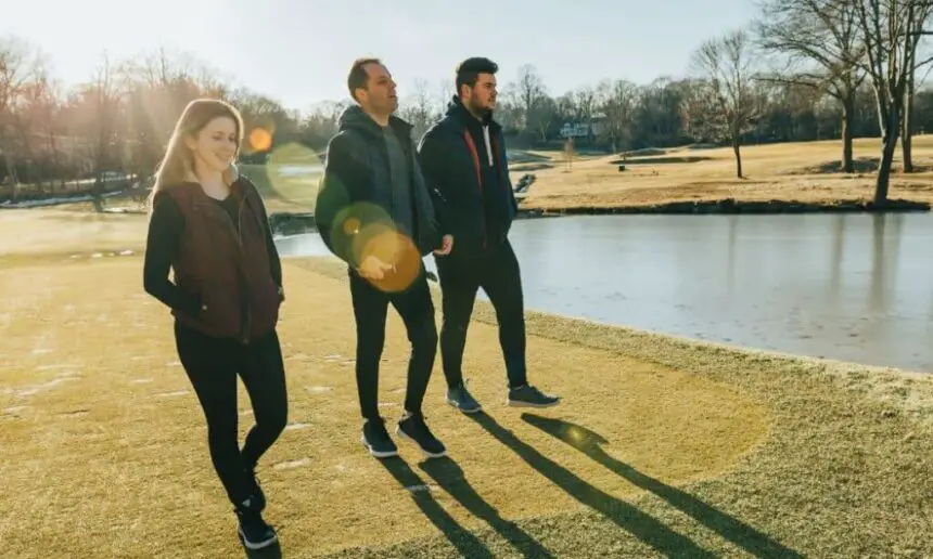 Three friends walking on the golf course.