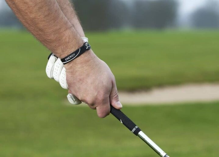 Golfer holding a golf club by the grip.