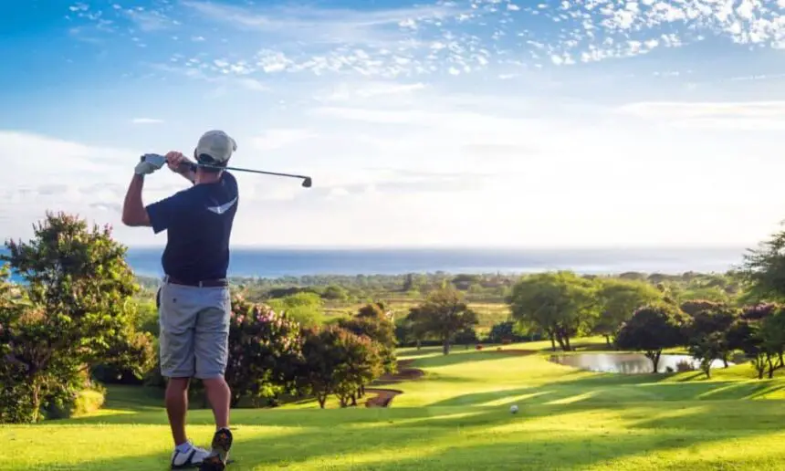 Golfer hitting ball downhill.